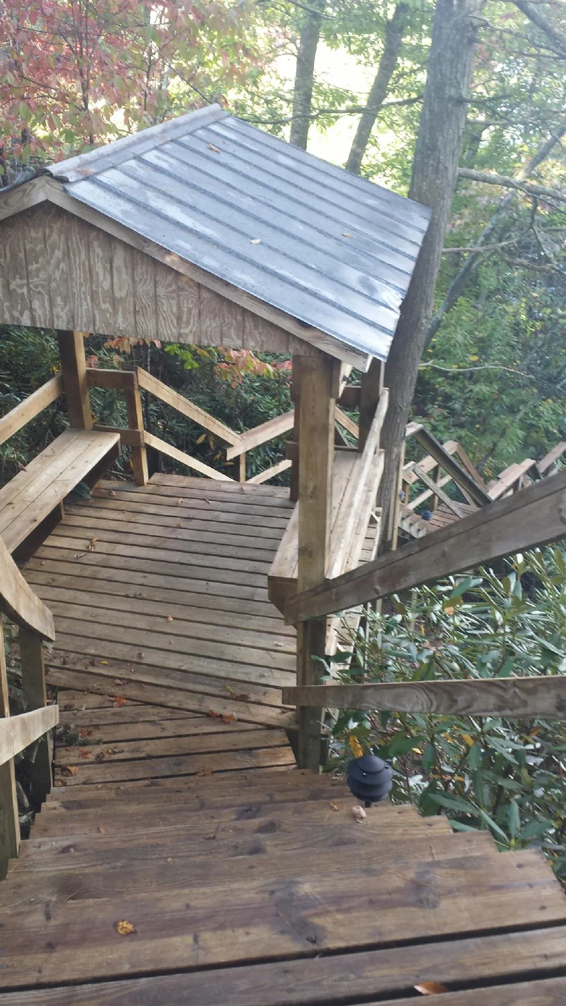 Metal roofed shelter over wooden steps on a wooded walkway — Skylight Repair & Installation work by our crew in Kendleton