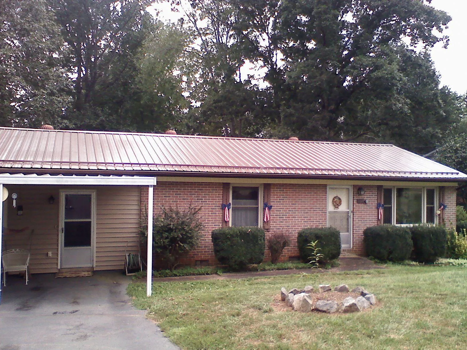 Bronze metal roof and carport on a brick ranch home — Roof Repair work by our crew in Kendleton