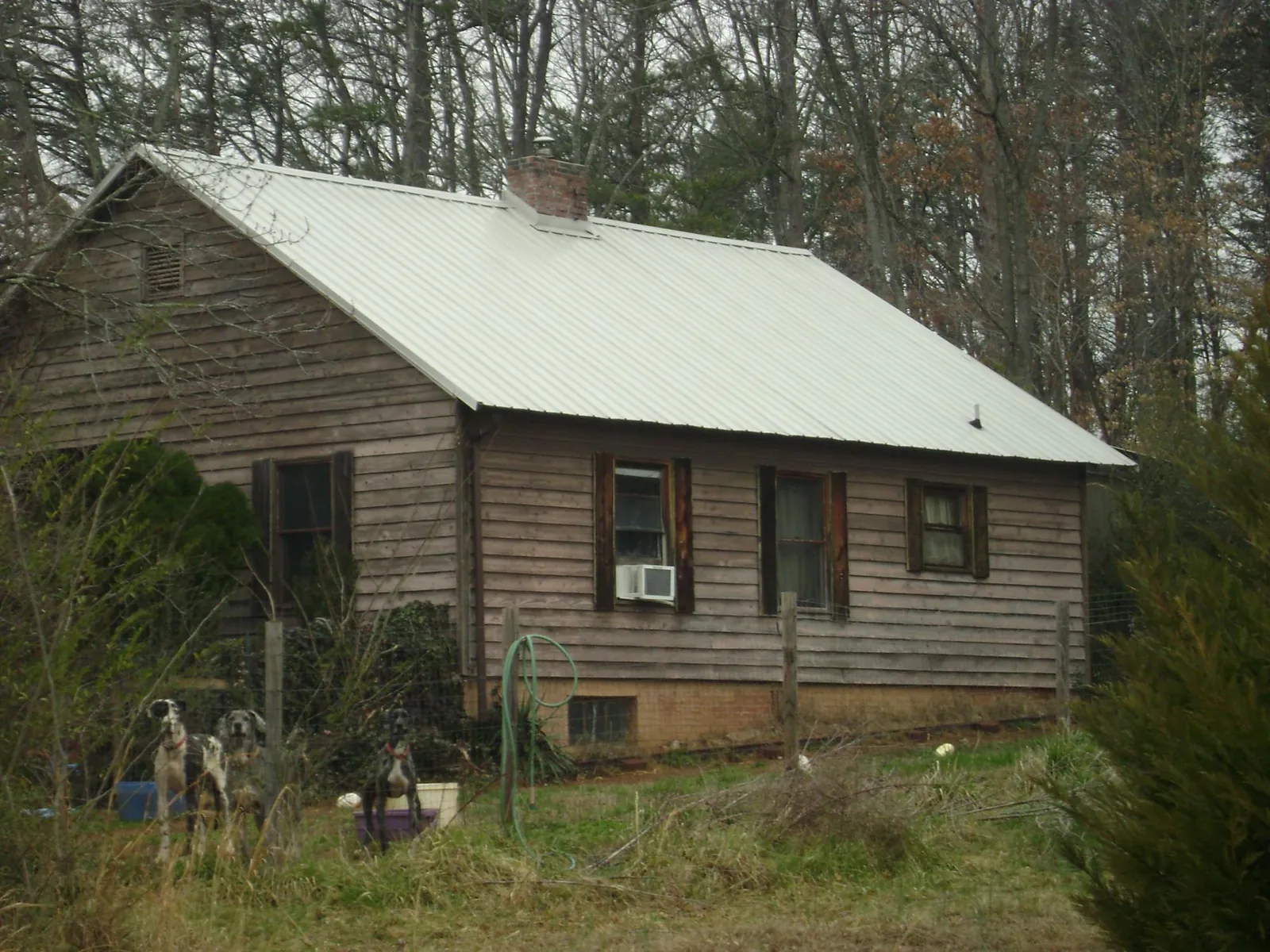 White metal roof on an old wood sided farmhouse, from a Asphalt Shingle Roof Repair job in Kendleton